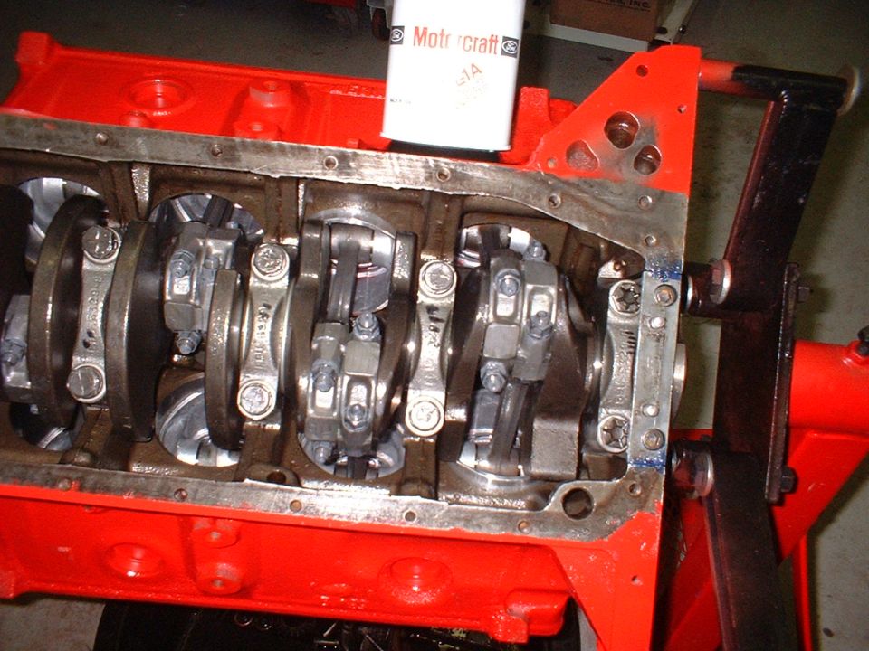 Engine block with crankshaft and connecting rods visible, oil filter on top