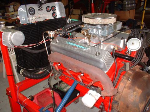 1955 Ford Thunderbird - Engine assembly with "Thunderbird" script on valve cover, mounted on a red stand with gauges and a radiator.