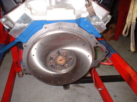 1967 Ford Mustang - Engine block and flywheel assembly on a red engine stand, with visible Edelbrock branding.