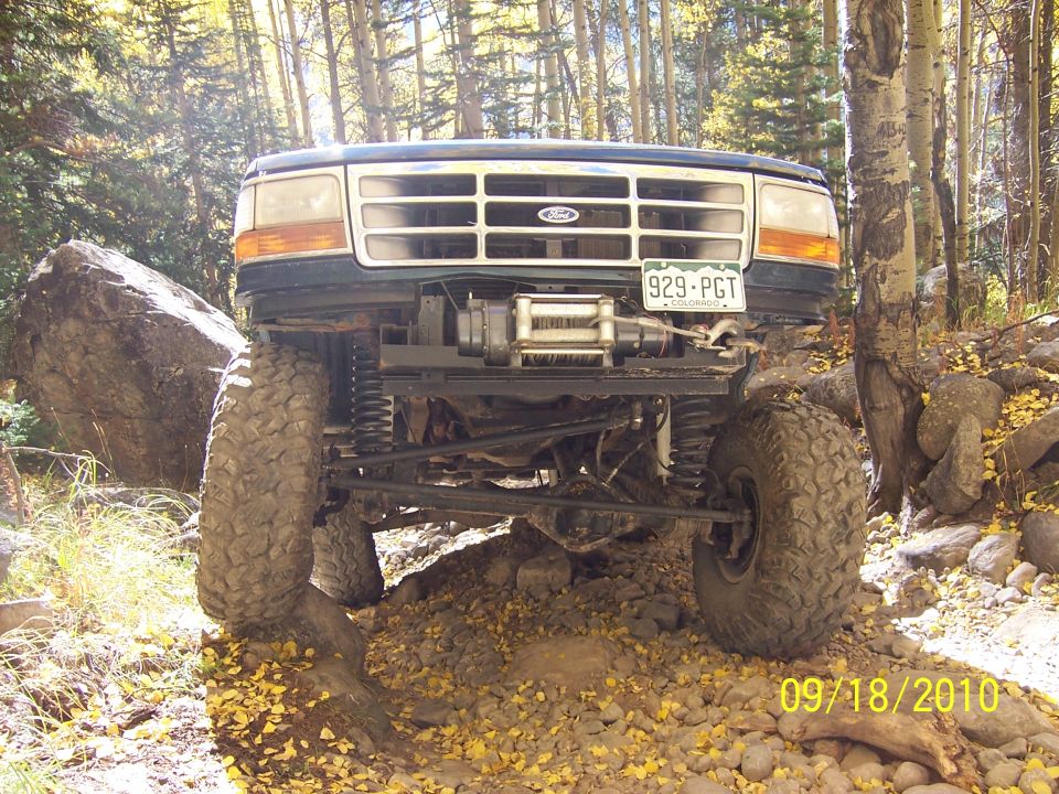 1994 Ford Bronco front view, lifted with large tires, on a rocky trail