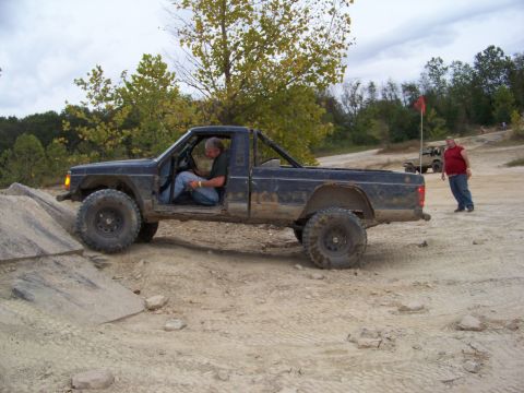 1989 Ford Bronco - Pickup truck navigating an off-road obstacle course with another vehicle in the distance.