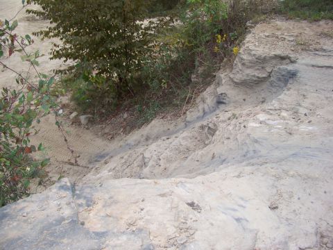 1989 Ford Bronco - Tire tracks mark a path down a sandy, eroded slope in an outdoor setting.