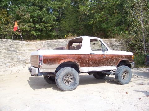 1989 Ford Bronco - This lifted 1989 Ford Bronco, seen from the side, is equipped with an orange and red flag on a pole.