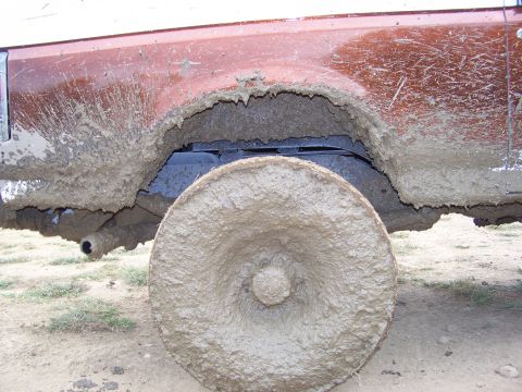 1989 Ford Bronco - This vehicle's wheel and fender are heavily covered in mud, making identification difficult.