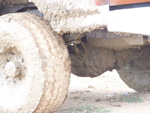 1989 Ford Bronco - Undercarriage of a heavily mud-covered vehicle, showing a tire and suspension components.