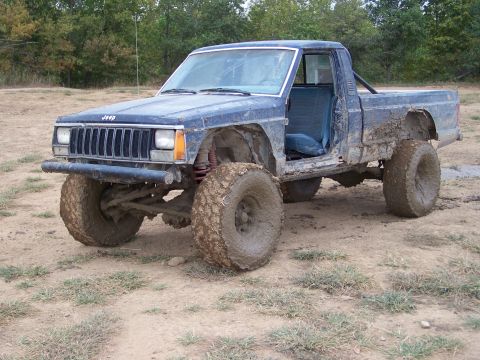 1989 Ford Bronco - This modified Jeep Comanche pickup truck is covered in mud after off-roading.