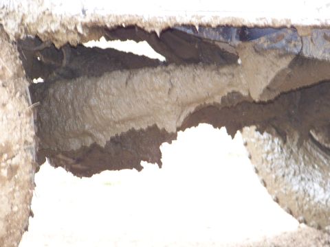 1989 Ford Bronco - Thick mud coats the undercarriage of a vehicle, obscuring its make and model.