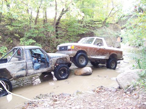 1989 Ford Bronco - Two off-road vehicles tackle a challenging water crossing during a weekend outing.