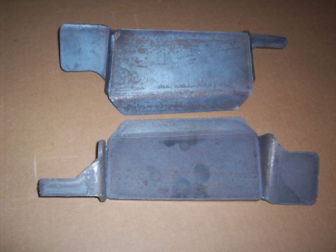 1969 Ford Torino - Two metal brackets with visible rust and mounting tabs are shown against a plain background.