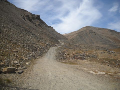 1986 Ford Bronco II - A rough, unpaved road winds its way up a barren, rocky mountainside.