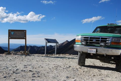 1996 Ford Bronco - A green 1996 Ford Bronco is parked at Engineer Pass, elevation 12,800 feet, under a bright blue sky.