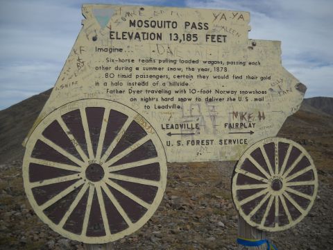 1986 Ford Bronco II - A weathered sign at Mosquito Pass, elevation 13,185 feet, displays historical text and graffiti.