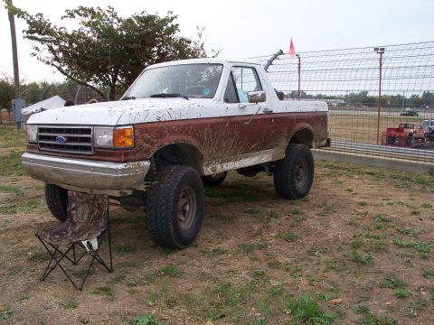 1989 Ford Bronco - This lifted 1989 Ford Bronco is covered in mud, suggesting it has seen some off-road action.