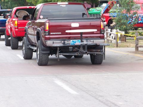1989 Ford Bronco - Maroon GMC Sierra pickup truck seen in a line of vehicles.