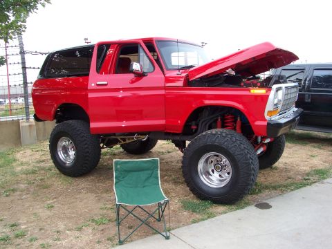 1989 Ford Bronco - This modified Ford Bronco features a lifted suspension and oversized tires, with its hood open for display.