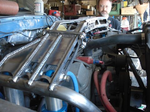 1986 Ford Bronco - Close-up of custom metal fabrication work on a vehicle's engine bay, with a person in the background.