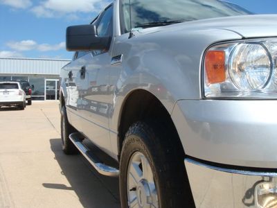 2004 Ford F-150 - A silver 2004 Ford F-150 is parked on a sunny day. Another white vehicle is visible in the background.