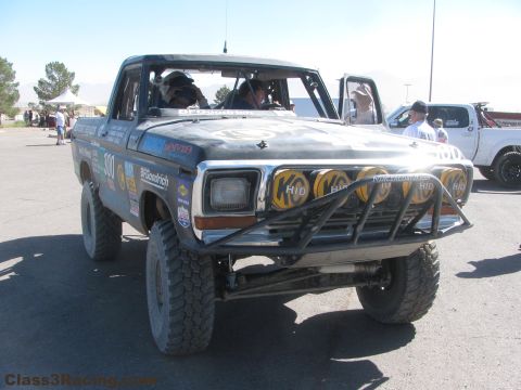 1990 Ford Bronco - Front view of the black number 300 race truck fitted with a bar of yellow HID driving lights and a tubular bumper.