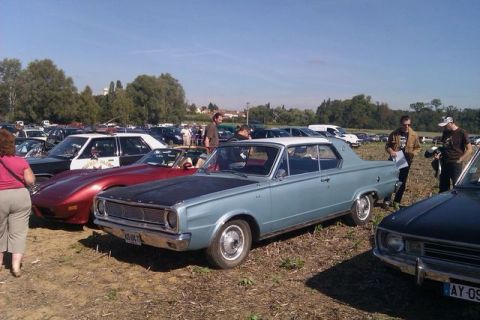 1991 Ford Crown Victoria - A light blue 1967 Dodge Dart coupe with a black hood is parked at an outdoor car show.