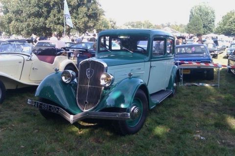 1991 Ford Crown Victoria - A vintage two-tone sedan is parked on grass at an outdoor event with other vehicles visible.
