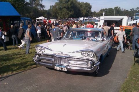 1991 Ford Crown Victoria - A classic 1959 Dodge Custom Royal is displayed at an outdoor event with spectators around.