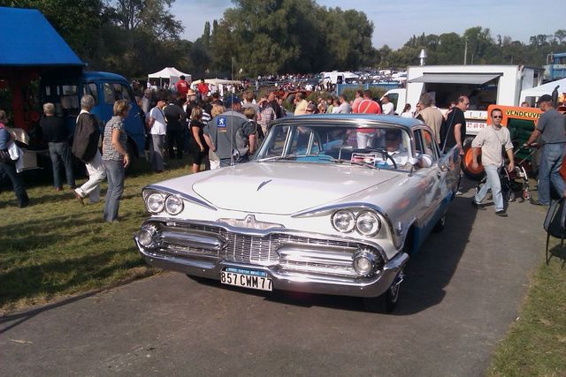 White and light blue 1959 Dodge Custom Royal with chrome grille and dual headlights, parked on asphalt