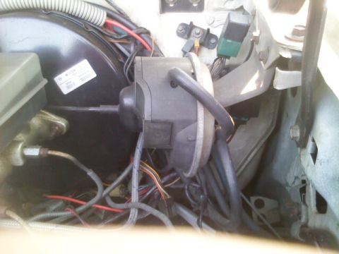 1986 Ford Bronco - Close-up view of engine bay components, including brake booster and various hoses and wiring.
