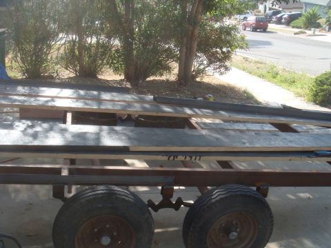 1992 Ford Bronco - Trailer frame with wood planks. A red vehicle is visible in the background.