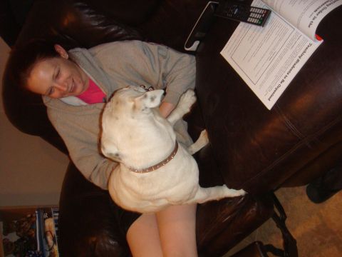 1992 Ford Bronco - A woman relaxes on a brown leather couch with her dog, while papers and a remote control rest on the armrest.