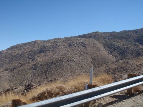 1992 Ford Bronco - A view of a dry, mountainous terrain under a bright blue sky, with a guardrail along the side of the road.