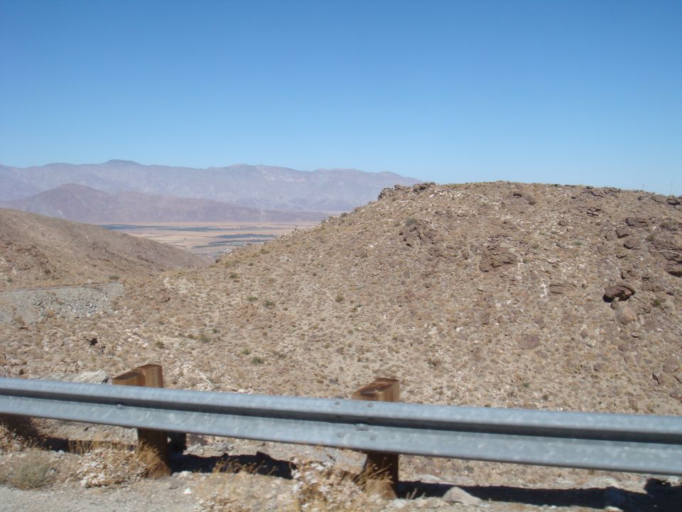 Desert landscape with mountains and a guardrail in the foreground