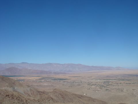 1992 Ford Bronco - A wide view of a desert landscape under a clear blue sky, with mountains in the distance and a small town visible in the valley.