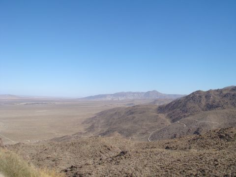 1992 Ford Bronco - A vast desert landscape stretches out under a clear blue sky, with hills in the foreground.