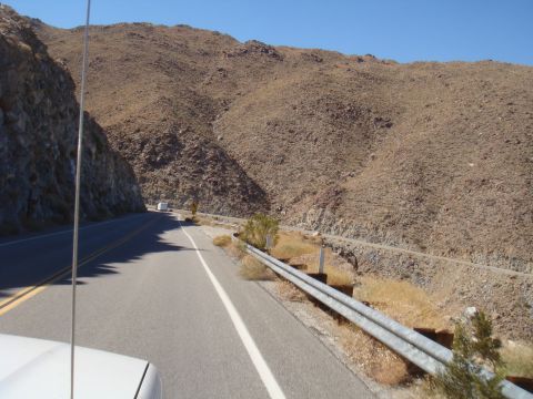 1992 Ford Bronco - View from a vehicle traveling on a highway through a barren, mountainous region on a sunny day.