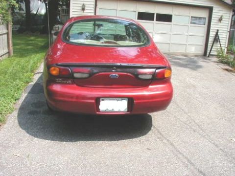 1997 Ford Taurus - Rear view of a red 1997 Ford Taurus sedan parked in a driveway.
