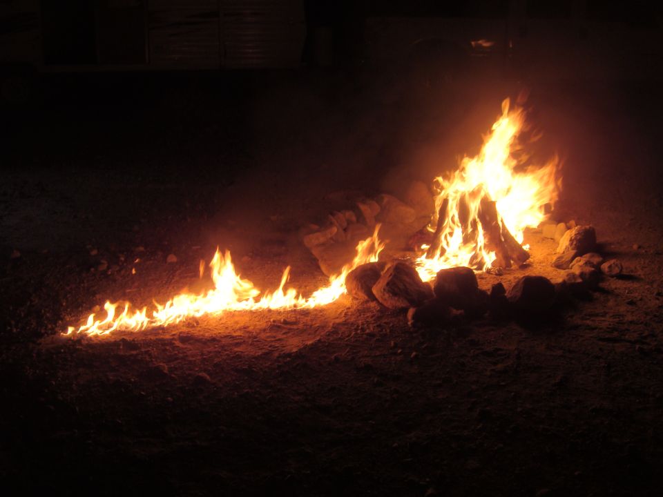 Campfire burning at night with rocks around it