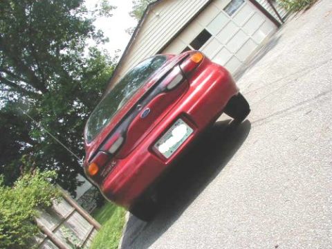 1997 Ford Taurus - Rear view of a red 1997 Ford Taurus parked on a driveway.