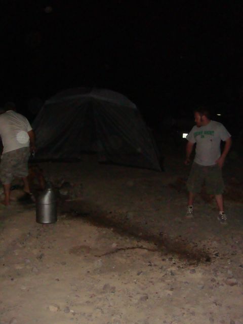 1992 Ford Bronco - A nighttime scene with two people and a tent set up in a dirt area.