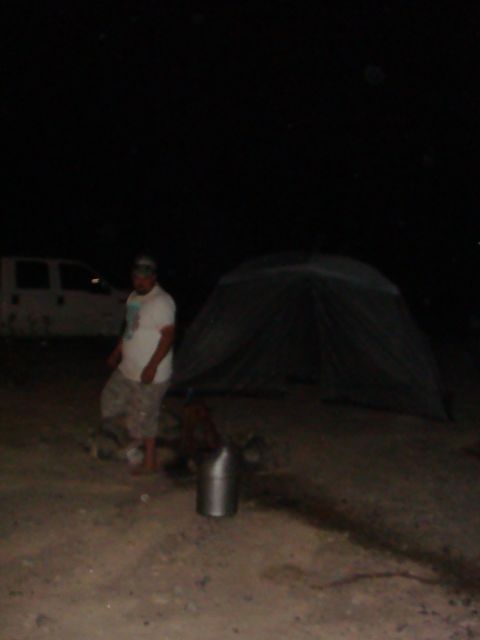 1992 Ford Bronco - A white van is visible parked on dirt ground at night next to a tent and a person.