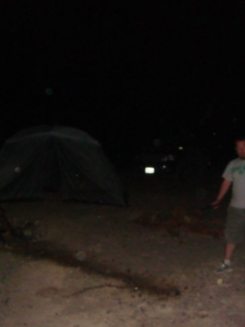 1992 Ford Bronco - A tent and a person are visible at night, with a faint light from a distant vehicle in the background.