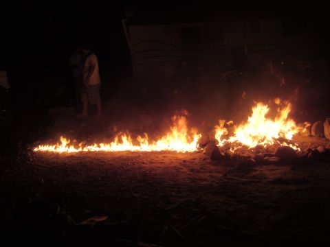 1992 Ford Bronco - A large bonfire burns brightly at night, with two figures visible in the dark background.