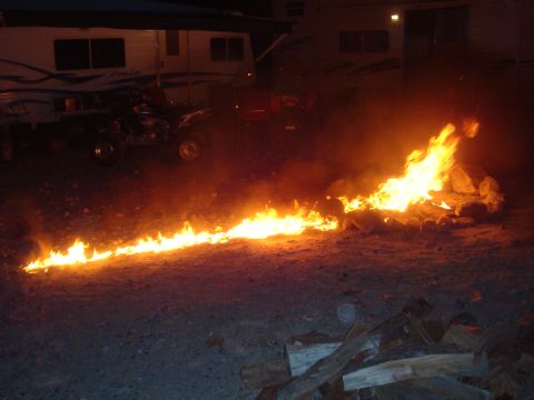 1992 Ford Bronco - Campfire burning in front of an RV at night.