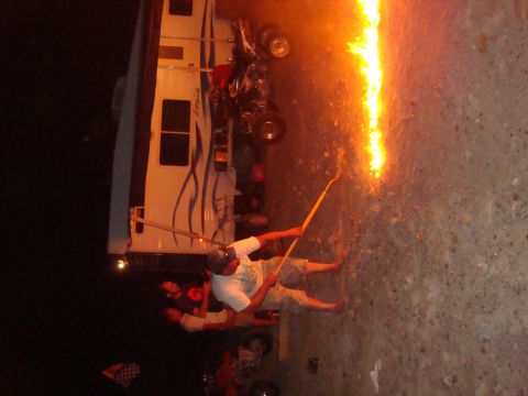 1992 Ford Bronco - People are playing with fire near an RV at night.