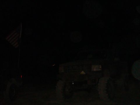 1992 Ford Bronco - A dark truck is visible at night next to an American flag.