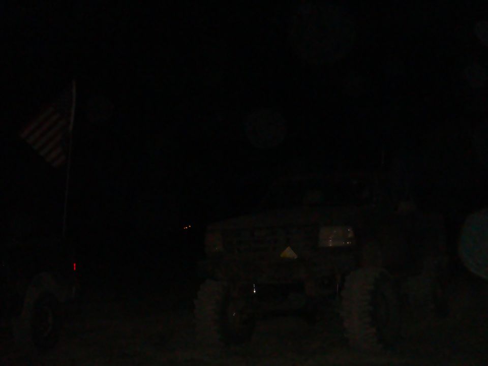 Dark truck with American flag on pole to the left