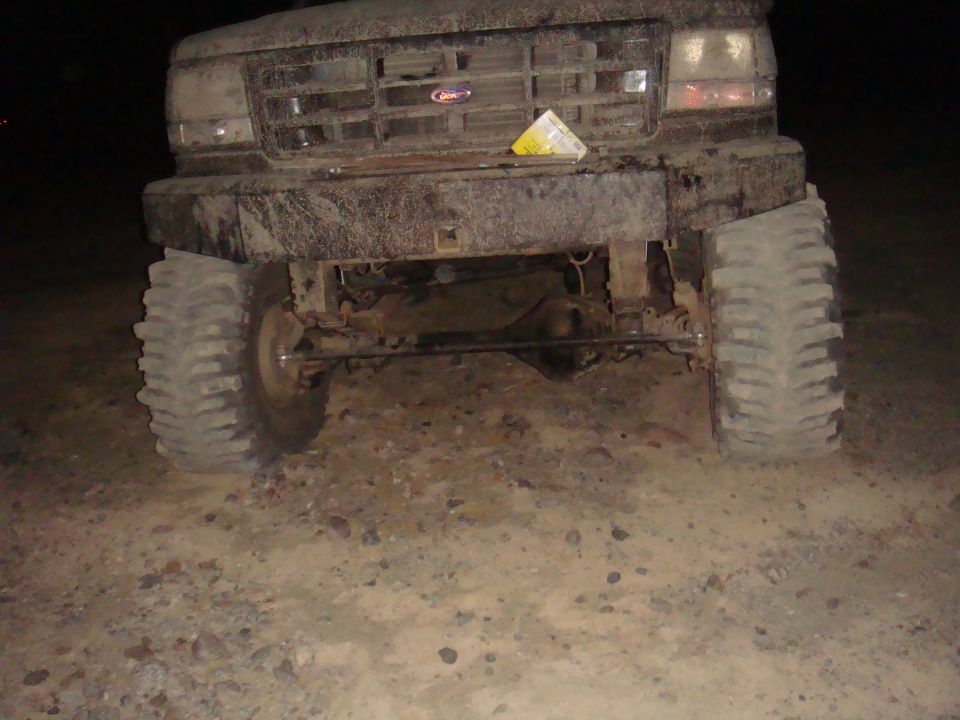 Front view of a muddy 1992 Ford Bronco with large tires