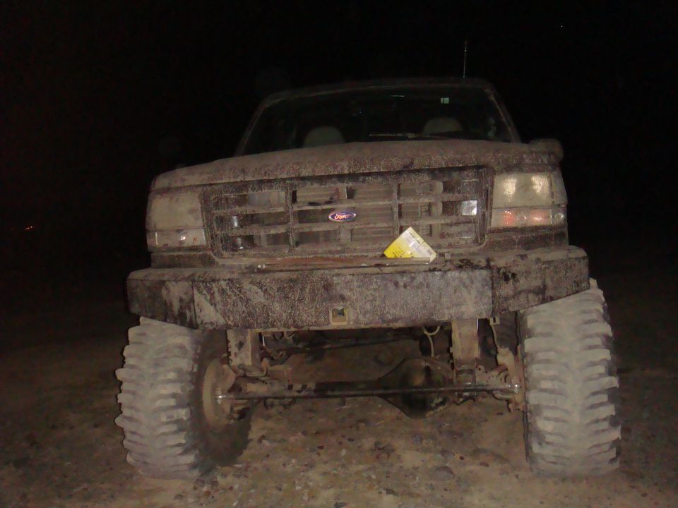 Mud-covered 1992 Ford Bronco front view, with large tires and a custom bumper