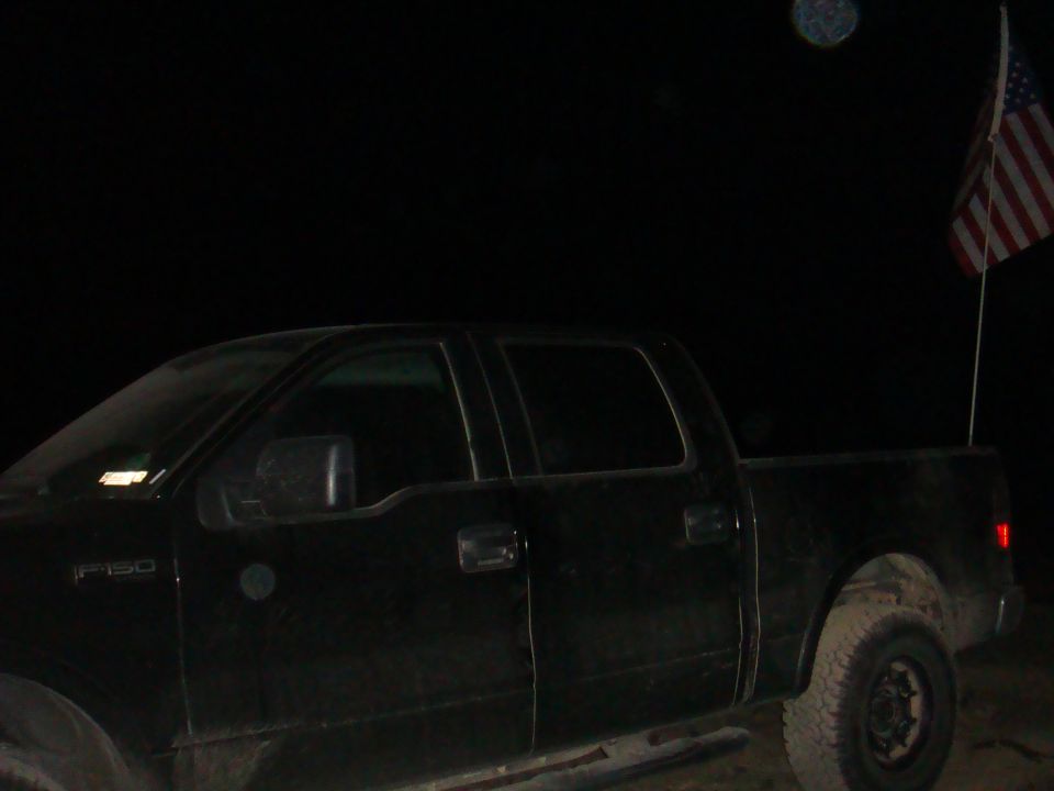 Black pickup truck side view with American flag