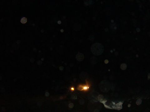 1992 Ford Bronco - Water droplets obscure the view of a vehicle's headlights at night.
