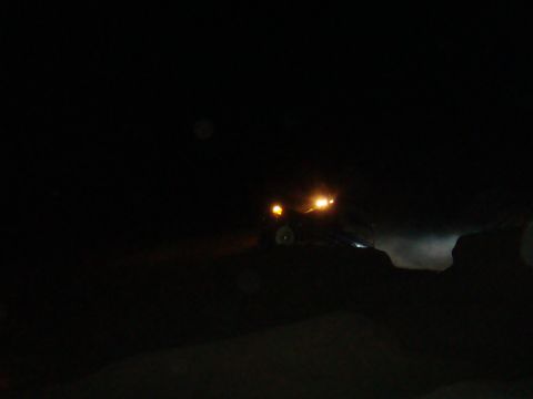 1992 Ford Bronco - Off-road vehicle driving at night with headlights illuminating the path ahead.